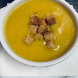 Crema de verduras con toque de aceite de oliva virgen y escamas de parmesano.