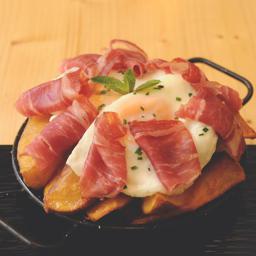 Huevos rotos con patatas y virutas de jamón ibérico