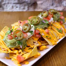 Nachos con queso fundido, guacamoles, pico de gallo y jalapeños