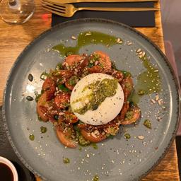Burrata di bufala con tomate, pesto y piñones